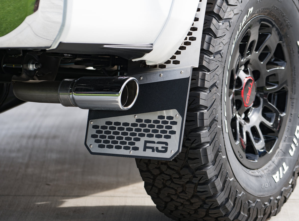 Close-up of a REKmesh bracket and flap behind an off-road tire